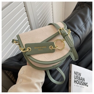 Detail of color-block saddle bag featuring cream croc-textured leather and gold ring buckle