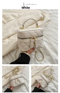 Detail of white quilted crossbody bag with gold camellia charm and leather chain strap