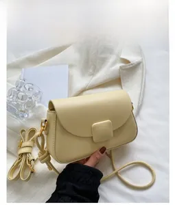 Détail du sac à bandoulière jaune vif montrant la boucle et l'attache de la bandoulière