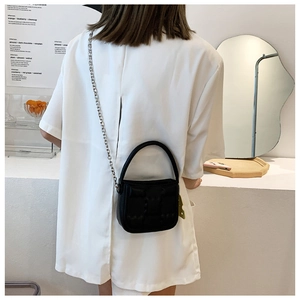 Detailansicht der gesteppten schwarzen Puffer-Handtasche mit Kettenriemen an einem Modell