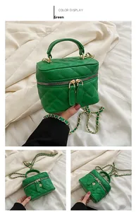 Detail of green quilted crossbody bag with dual floral zippers and gold chain strap