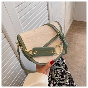 Detail of crocodile pattern saddle bag with cream and avocado green color contrast