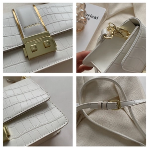 Detail view of white crocodile pattern shoulder bag with gold clasp and fashion text