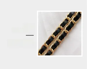 Detail magnification of the golden hardware chain interwoven with black leather