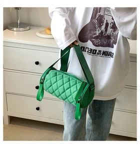Close-up of vibrant green nylon cylinder crossbody bag with quilted diamond pattern