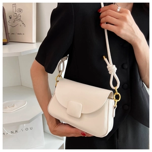 Vue détaillée d'un sac bandoulière crème minimaliste avec boucle carrée et métal doré