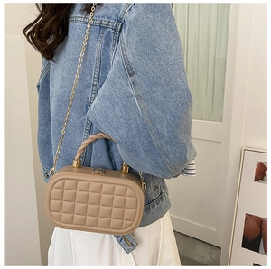 Quilted box bag with knot handle and gold chain strap shown on a model