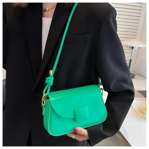 Détail du sac à bandoulière vert vif avec sangle nouée et design moderne à rabat
