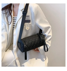 Quilted black nylon cylinder crossbody bag shown on model for size and style reference