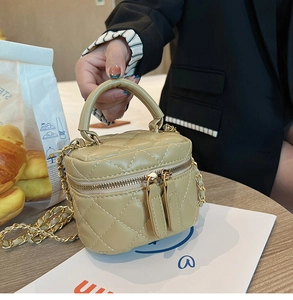 Detail of khaki quilted mini box bag with golden chain strap and dual zipper closure