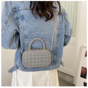 Grey quilted box bag with gold chain strap and rope handle worn by a model