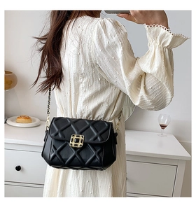 Schicke schwarze Stepptasche mit Kette in einem anspruchsvollen Wohnstil-Ambiente
