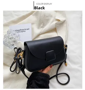 Détail du sac bandoulière en cuir noir mat avec boucle carrée et anneaux métalliques dorés