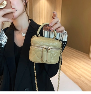Detailed close-up of a mini quilted vanity bag with gold chain and top handle in beige