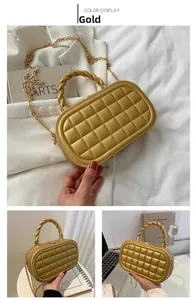 Detail view of a gold quilted box bag with a twisted metal handle and gold chain strap