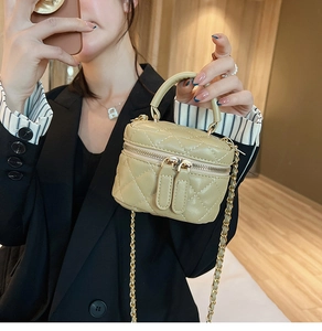 Quilted leather mini vanity case in khaki with chain strap shown on a striped blazer