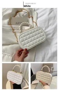 Detail of white quilted box bag featuring golden chain and woven handle strap