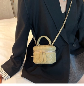 Olive green quilted mini box bag with chain strap shown on model for size and style