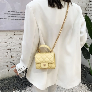 Quilted mini cloud bag in yellow with gold flower buckle and chain strap on model