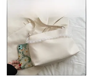Size comparison of a cream crossbody bag with acrylic chain and daisy phone