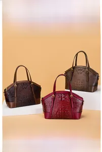 Three shell-shaped handbags in crocodile embossed leather in wine, coffee, and tan colors