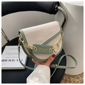Detail of saddle bag showing cream crocodile texture and sage green leather accents