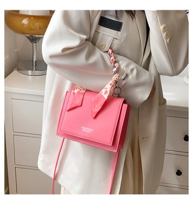 Pink crossbody bag with silk scarf metal chain handle shown on model for size and style
