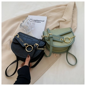 Detail of crocodile embossed saddle bags in black and sage green with gold accents