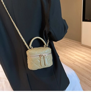 Detail of light khaki quilted vanity bag with gold chain strap and top handle