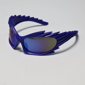 Close-up of blue Y2K wraparound sunglasses with flame-edged frames and gradient lenses