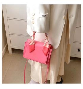 Chic pink crossbody bag with leopard print silk scarf on handle worn by model