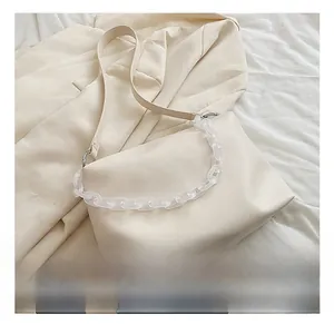 Detail of minimalist beige faux leather shoulder bag with frosted acrylic chain