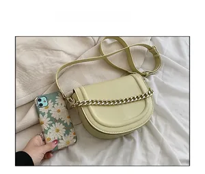 Top view of yellow saddle bag with gold chain showing size comparison with a smartphone