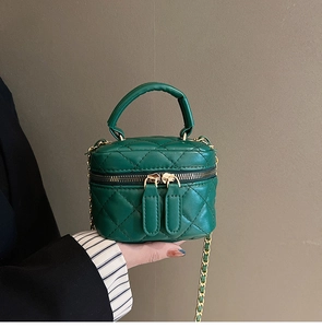 Detail view of mini dark green quilted crossbody bag with gold chain and top handle