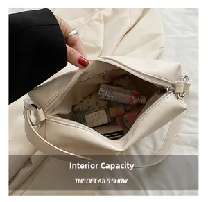 Detailed internal capacity showing large space and zipper pocket of the cream underarm bag