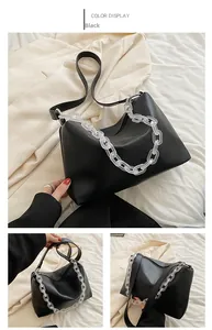 Detail of black PU leather shoulder bag featuring a white acrylic decorative chain