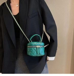 Detail of green quilted mini vanity bag with gold-tone hardware and chain strap