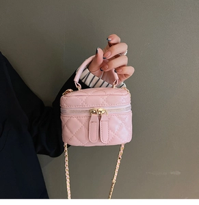 Detail of pink quilted PU leather micro vanity bag with gold chain and dual zipper