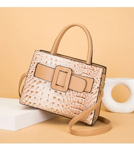 Detail of beige crocodile pattern handbag with large buckle and stylish shoulder strap