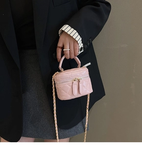 Detail of pink quilted vanity bag with gold chain strap on professional model