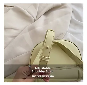 Detail of adjustable leather strap with gold buckle on yellow saddle crossbody bag