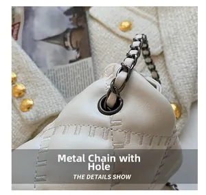 Close-up of the metal chain strap and quilted faux leather texture on the cream shoulder bag