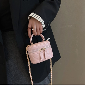 Detail of pink quilted mini crossbody bag with gold chain strap and top handle