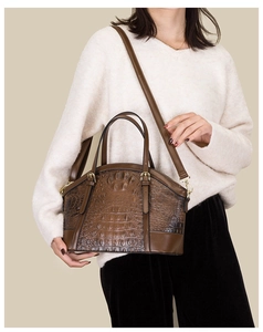 Detail of vintage brown crocodile embossed dome bag with dual handles and long shoulder strap