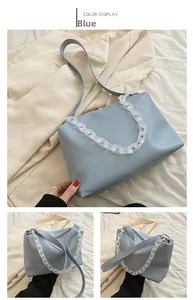 Detail of light blue faux leather bag with translucent white acrylic chain and zipper
