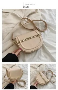 Detail view of khaki saddle bag with golden chain accent and adjustable shoulder strap