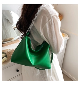 Detail of soft green faux leather hobo bag with thick frosted white acrylic chain strap