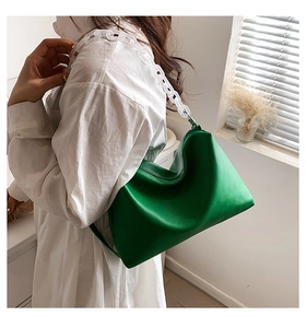 Close-up of bright green PU leather shoulder bag with white chunky acrylic chain handle