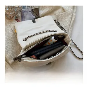 Internal view of quilted white leather crossbody bag showing spacious capacity and chain strap