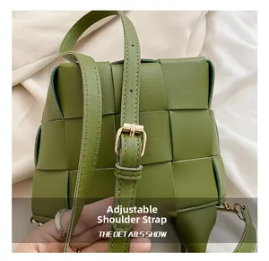 Detail view of the green woven leather bag with an adjustable gold buckle strap